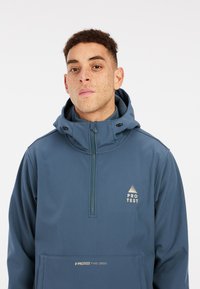 Pullover-Jacke in Dunkelblau mit einem Reißverschlusskragen, einer Kapuze und einer Vordertasche mit Logo. Hergestellt aus glattem, leichtem Material.