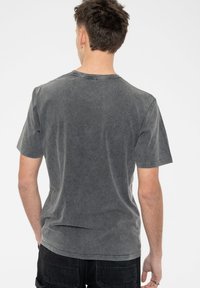 Gray cotton t-shirt with a crew neck, short sleeves, and a faded texture. Features a simple, seamless back design without logos.