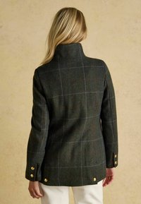 Giacca di lana a scacchi verde con colletto alto, dotata di bottoni dorati sulle maniche e sul retro, e un finish testurizzato.