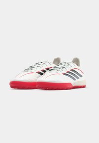 Άσπρα αθλητικά παπούτσια με κόκκινη σόλα, με μα ύρες ρίγες και γκρι λεπτομέρειες, λεία υφή και καμπυλωτό σχέδιο στο μπροστινό μέρος.