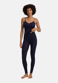 Námořnická modrá úzká bezrukávová body s tenkými ramínky, hladkým povrchem a výřezem v pase. Úzká část nohavic.