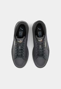 Black athletic shoes with a smooth leather upper, round toe, flat laces, gold logo accents, and cushioned insoles.