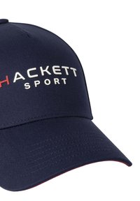 Marineblaue Baseballkappe aus Stoff mit strukturiertem Design. Sie verfügt über einen gebogenen Schirm und ein weißes "HACKETT SPORT" Logo mit roten Akzenten.