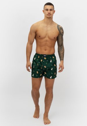 Grüne gemusterte Boxershorts mit Lebkuchenmann- und Schneemannmotiven, aus weichem Stoff mit einem elastischen Bund und Knopfverschluss.
