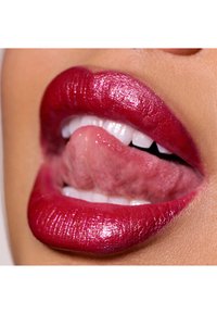 Lèvres brillantes et rose foncé avec paillettes, légèrement ouvertes pour révéler des dents blanches. Texture visible avec une forme définie et des contours lisses.