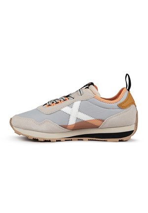 Zapatillas gris claro con un upper de ante texturizado y sintético. Presenta una franja diagonal blanca, acentos naranjas y una suela negra.
