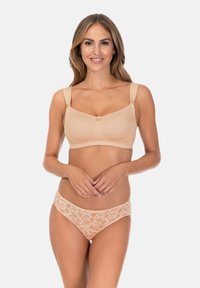 Beżowy bezprzewodowy biustonosz z teksturowanymi ramiączkami i dwoma ozdobnymi kokardkami; w zestawie z dopasowanymi koronkowymi majtkami zdobionymi kwiatowymi wzorami.