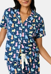 Mörkblå pyjamas set med ett lekfullt mönster av färgglada hundar. Innehåller en kortärmad topp, knappframsida och dragsko i midjan på byxorna.