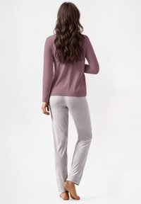 Pigiama da donna composto da una maglietta a maniche lunghe color malva e pantaloni grigi chiari con righe verticali. Tessuto morbido e leggero per il massimo comfort.