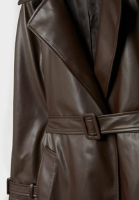 Trench-coat en simili cuir marron foncé avec grand col à revers, ceinture avec boucle rectangulaire et poches latérales.