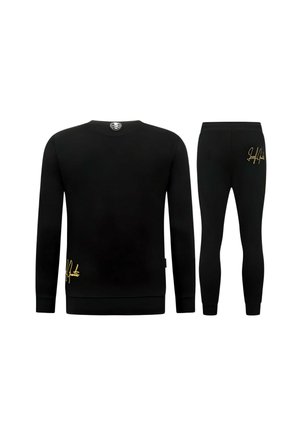 Zwarte longsleeve trui en bijpassende broek van achteren gezien, beide met kleine gouden signatuurdetails aan de onderzijden.