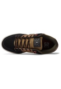 Melnas un brūnas kedas ar zamšā un auduma virsu, ar rakstainām šņorēm, mīkstu mēli un gumijas zoli. DC logo redzams.