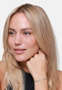 Bracciale a manica in argento con un design elegante e minimalista, caratterizzato da due bande parallele, texture liscia e finitura lucida.