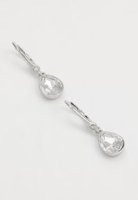 Orecchini in tono argento con cristalli trasparenti a goccia e piccoli accenti rotondi. Finitura metallica liscia e design classico.