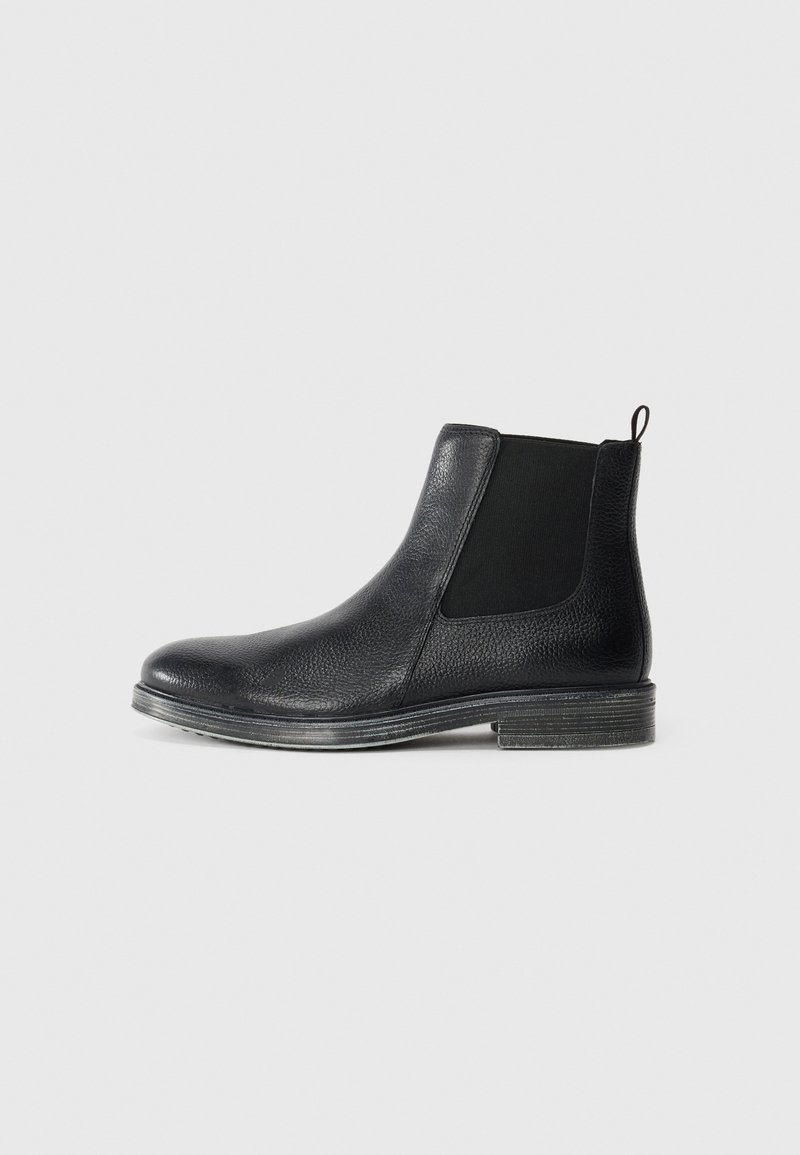 Bottines Chelsea en cuir noir avec une surface texturée, des panneaux élastiques sur les côtés et une languette. Elles disposent d'une semelle durable avec une légère élévation.