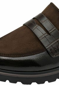 Brown suede shoe featuring a glossy black patent leather toe and two dark brown straps. Textured surface with rubber sole and tread.