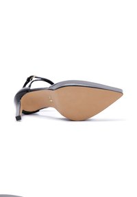 Escarpin en cuir verni noir avec un bout pointu et un talon fin. Présente une boucle en ton doré et des sangles texturées. Semelle beige lisse.