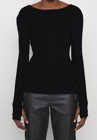 Black long-sleeve top with a wide, boat neckline, ribbed texture, and fitted shape. Paired with dark gray, slightly shiny pants.