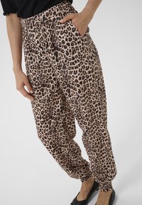 Pantaloni jogger con stampa leopardata in un tessuto morbido, con cintura e polsini elasticizzati, dotati di una tasca laterale e una vestibilità comoda.