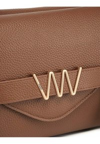 Hnědá kabelka z kůže s jemným zrnem, se zlatým kovovým logem "VW" a viditelným prošíváním na předním klopovém uzávěru.