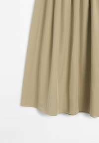 Jupe beige mi-longue à la taille froncée et drapé en tissu souple sur fond blanc.