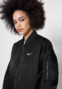 Nike Sportswear W NSW ESSNTL WVN BMR JKT IGNI - Bomber stiliaus striukė - black