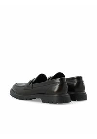 Mocasines de cuero negro con un acabado suave, que cuentan con una suela de suela gruesa y elementos decorativos en la parte superior. Diseño sin cordones.