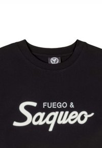 Camiseta de algodón negra con cuello redondo y letras blancas que dicen "FUEGO & Saqueo" en una fuente cursiva y en negrita.