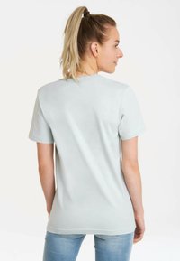 Light blue, short-sleeve T-shirt with a round neckline, smooth texture, and a fitted silhouette. No patterns or visible hardware details.