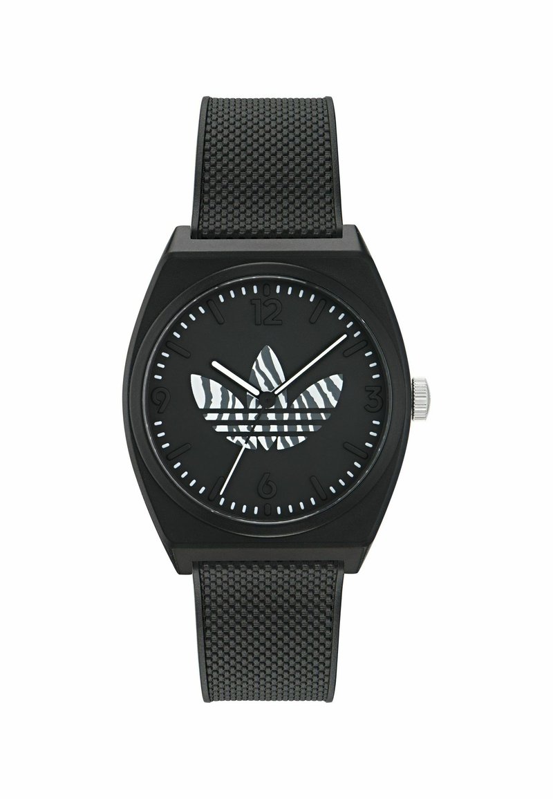 Montre noire avec un boîtier carré, bracelet en caoutchouc noir texturé et un cadran noir présentant un logo rayé de zèbre et des index horaires blancs.