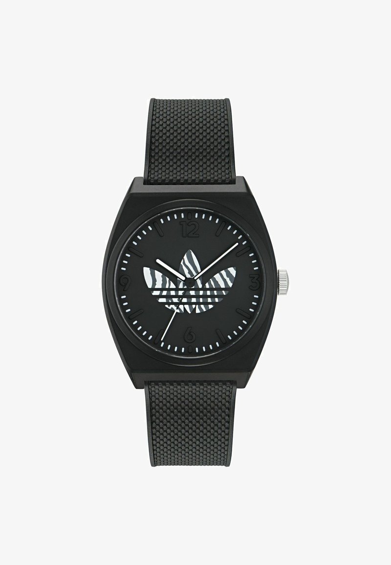 Melnas rokas pulkstenis ar kvadrātu formā veidotu korpusu, teksturētu melnu gumijas siksnu un melnu ciparnīcu ar zebra svītrām izmantotu logotipu un baltajiem stundu marķieriem.