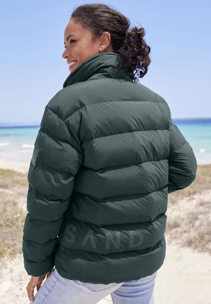 Dunkelgrüne Daunenjacke mit horizontalen Kammern, hohem Kragen und glatter Oberfläche. Markenlogo auf dem linken Ärmel sichtbar.