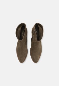 Botines de ante verde hasta el tobillo con punta afilada, cremalleras laterales y textura suave, que presentan un diseño de borde curvado para un aspecto elegante.