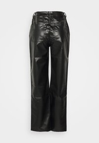 Pantaloni in pelle nera con vestibilità ampia, dotati di vita alta, tasche posteriori e una finitura testurizzata. Logo visibile in vita.