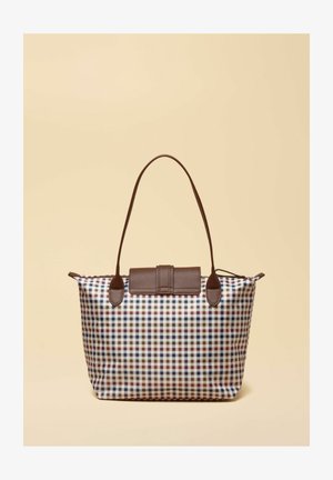Tragetasche mit kariertem Muster in Marineblau, Braun und Weiß, mit dunkelbraunem Ledergriff und Klappverschluss vor beigem Hintergrund.