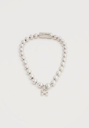 Strieborný náramok s korálkami, malým príveskom s motívom skrížených kosiek a magnetickým zapínaním na bielom pozadí.