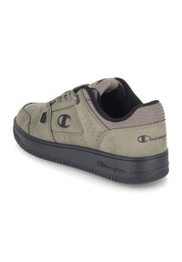 Zapatilla de gamuza verde oliva con suela de goma negra, detalles perforados y logo. Cuenta con un cuello acolchado y cierre de cordones.