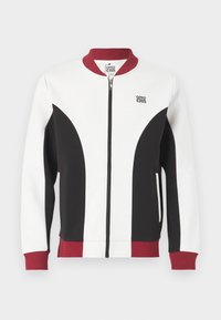 Zip-up jakke med en fargeblokkdesign i hvitt, svart og maroon. Har ribbestrikket krage og mansjetter, sidelommer og logo detalj.