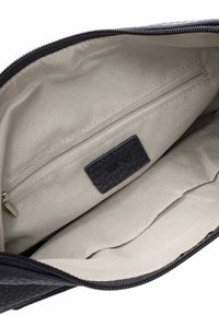 Interno di una borsa in pelle nera con fodera beige, una tasca con zip e un'etichetta con "RUE 09" impressa. Tessuto testurizzato con zip liscia.