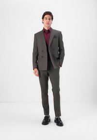 Gray plaid suit with a double-breasted blazer, slim-fit pants, and a maroon shirt. Black leather shoes complete the outfit.