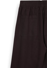 Dunkelbraune Hose mit elastischem Bund, ausgestattet mit zwei Gesäßtaschen, flacher Textur und geradem Bein. 