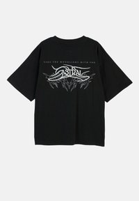 Czarny oversize t-shirt z białym wzorem graficznym z napisem "ZABIERZ KSIĘŻYCOWE ŚWIATŁO ZE SOBĄ" oraz słowem "ASTRAL" poniżej, krótki rękaw.
