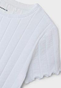 White ribbed short-sleeve top with a rounded neckline and scalloped edges, made of soft cotton, featuring a textured pattern.