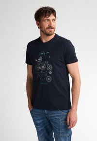 Maglietta in cotone blu navy con un grafico di parti di motocicletta in teal e argento. Maniche corte e design a girocollo.