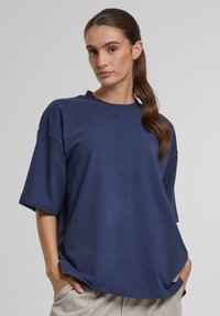 Marineblå oversized t-shirt lavet af blød bomuld, med korte ærmer og rund halsudskæring. Glat tekstur, afslappet pasform, ingen mønstre.