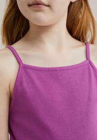 Lila ribbade linne med tunna axelband. Tyget är mjukt och elastiskt, med en enkel design och en tät passform. Inga anmärkningsvärda mönster eller detaljer.