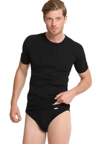 Svart kortärmad T-shirt i bomull, kombinerad med svarta kalsonger med en liten logotags. Fokus på passform och slät textur.