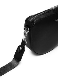 Schwarze Leder-Crossbody-Tasche mit runder Form, silberner Hardware und strukturiertem Tragegurt. Verfügt über einen Reißverschluss und eine glatte Oberfläche.