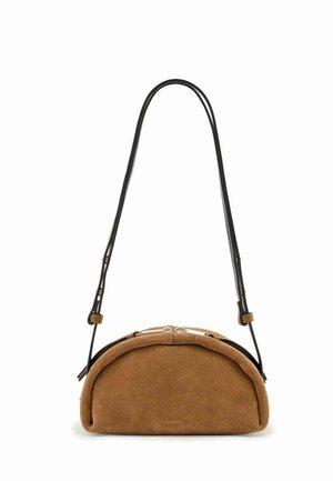 Sac à main en daim marron en forme de demi-lune avec une bandoulière noire réglable et une fermeture éclair argentée sur le dessus.