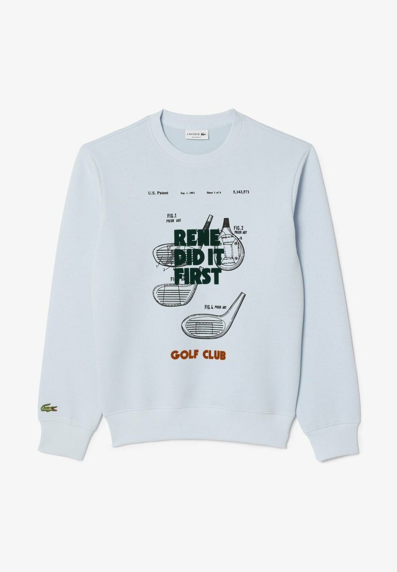 Sweat-shirt bleu clair avec des poignets côtelés, présentant un imprimé graphique de clubs de golf et du texte en vert foncé et orange. Matière en coton doux.